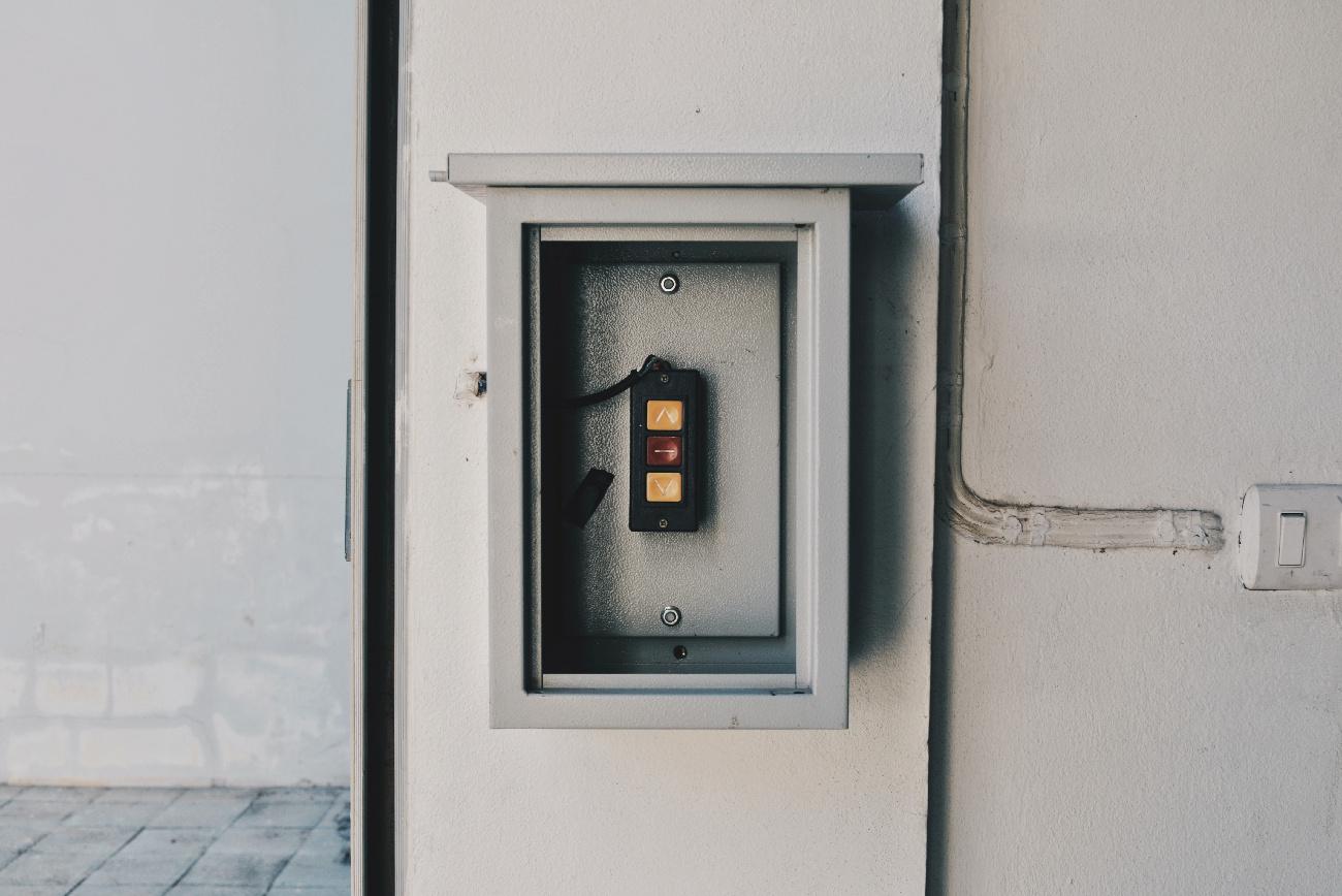 a grey box with three control buttons next to a switch