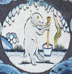 a medallion on part of an embroidered imperial robe with the White Hare of the Moon, at the foot of a cassia tree, making elixir of immortality