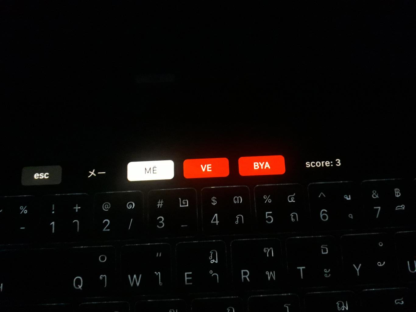 MacBook Touch Bar and backlit keyboard in the darkness