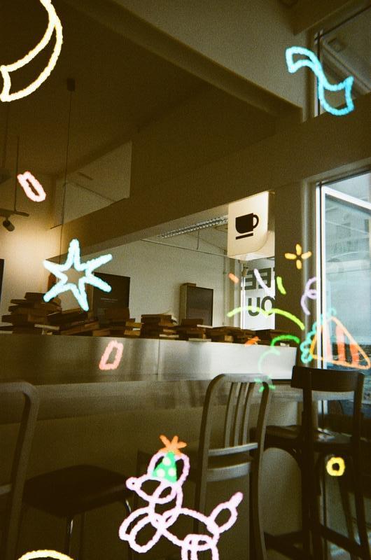 the interior of a café adorned with metal furniture and a lot of books